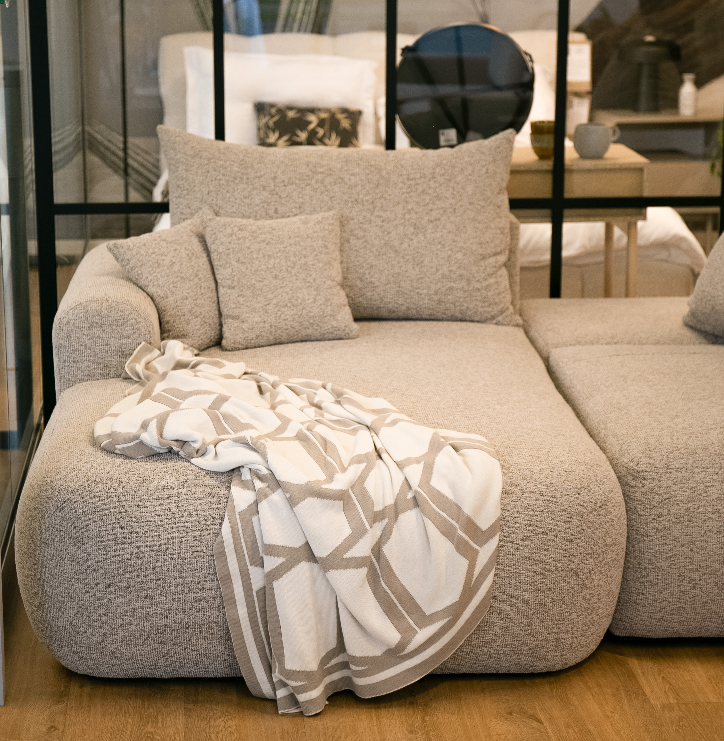 Jasnoszary narożnik Ovo lewostronny z funkcją spania i pojemnikiem na pościel.