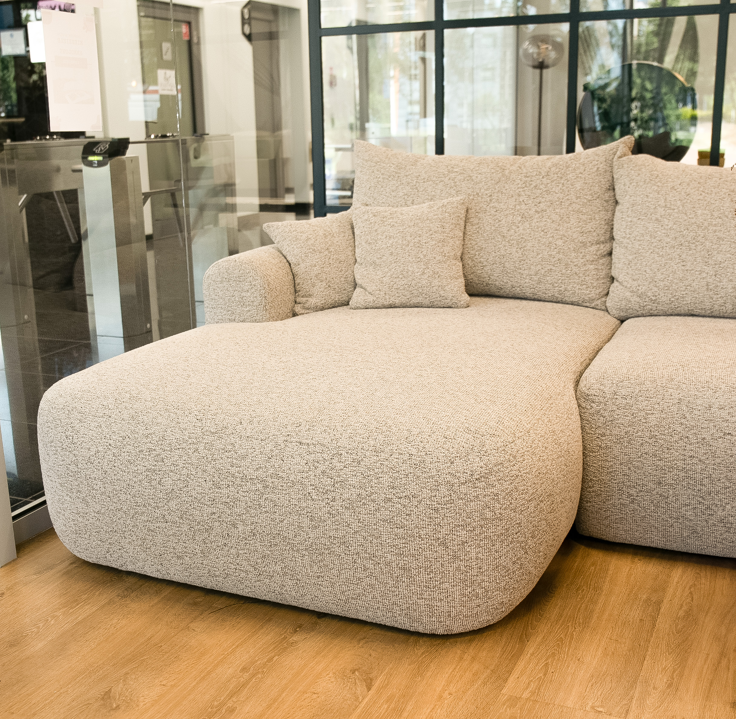 Jasnoszary narożnik Ovo lewostronny z funkcją spania i pojemnikiem na pościel.