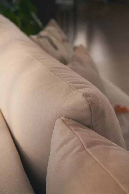 Kremowy narożnik Ovo mini L-kształtny z funkcją spania i pojemnikiem na pościel.