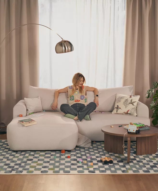 Kremowy narożnik Ovo mini L-kształtny z funkcją spania i pojemnikiem na pościel.